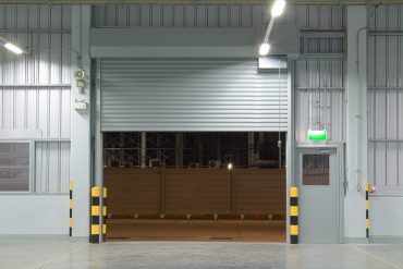 Open shutter door interior and concrete floor, night time.